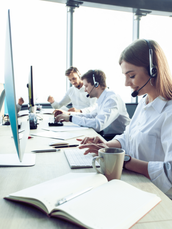Frau mit Headset tippt an der Tastatur und schaut darauf